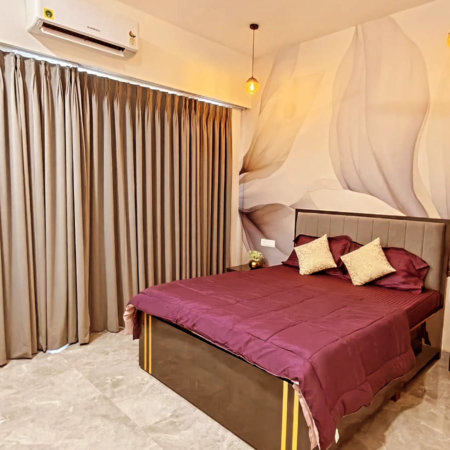 Maroon-themed bedroom with sculpted mural and pendant light