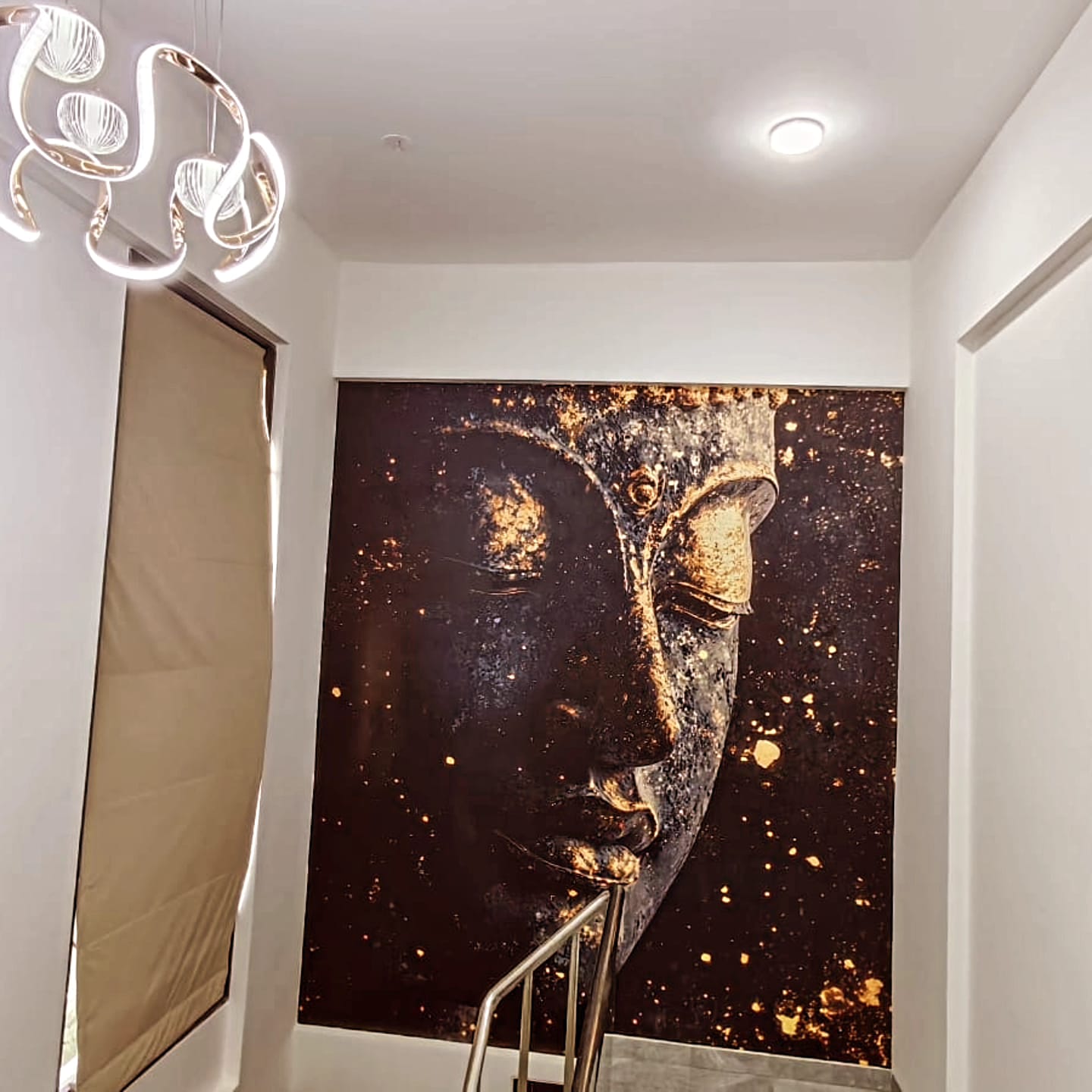 Staircase foyer with gold Buddha artwork and designer chandelier