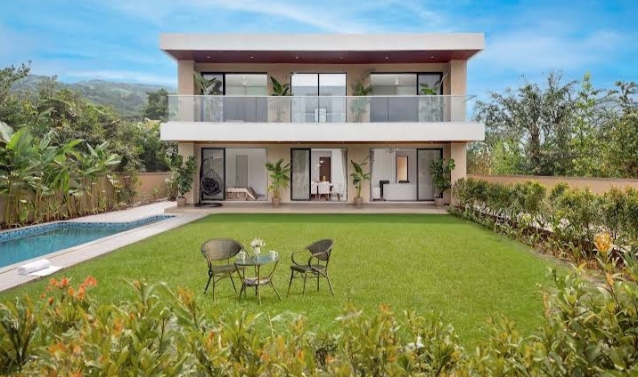 Monte Bliss villa exterior with manicured lawn, garden seating and the pool edge