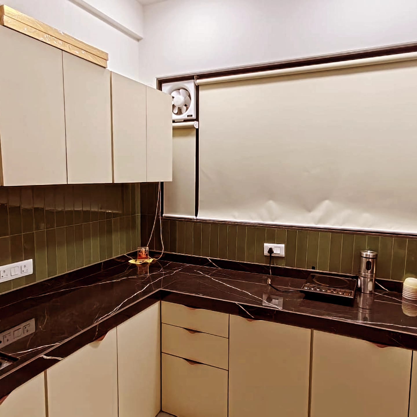 Modular kitchen with marble counter and olive tile backsplash